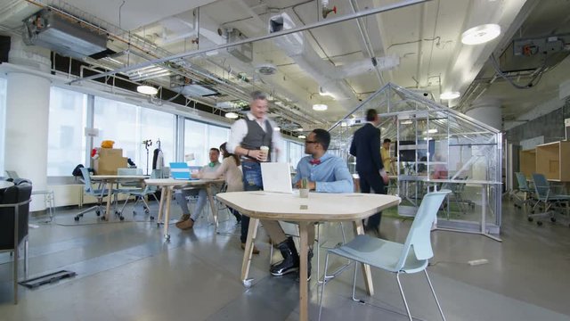  Time lapse of busy creative business team working hard in trendy office