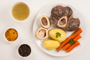 High angle view of a pot au feu, a french beef stew on a white plate and background