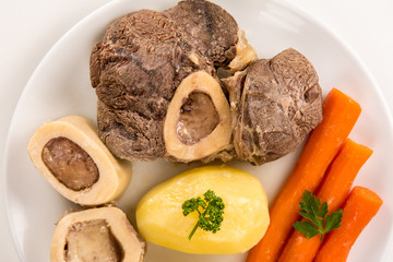 High angle view of a closeup of a pot au feu, a french beef stew on a white plate and background
