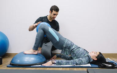 male physio therapist and woman helping patient