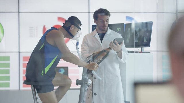  Athlete in scientific research program being tested by scientist in white coat. 