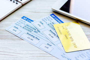 Buying airline tickets online with credit cards on table background