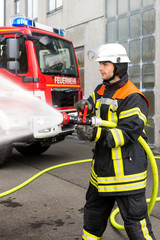 Fototapeta premium Strażak gaszący wężem