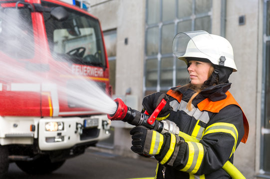Junge Feuerwehrfrau löscht ein Feuer