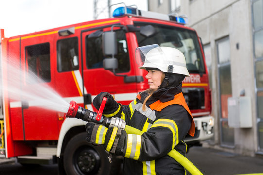 Junge Feuerwehrfrau löscht ein Feuer