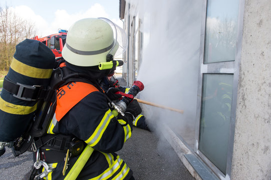 Feuerwehrmänner löschen brennendes Gebäude