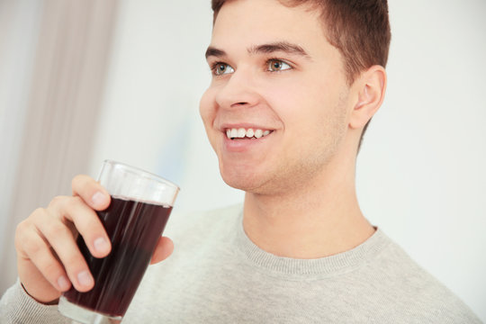 Young man drinking juice at home