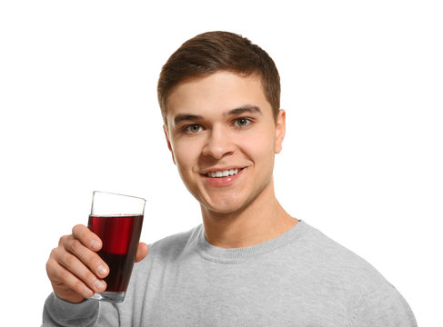 Young man drinking juice on white background