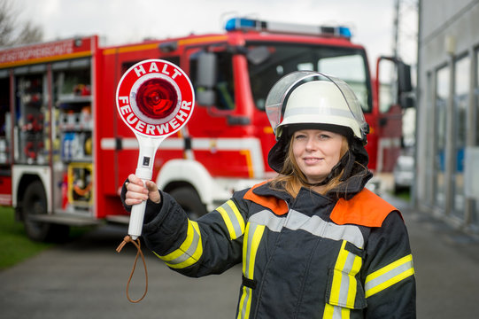 Feuerwehrfrau mit Anhaltekelle