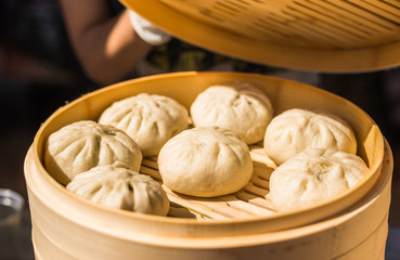 Asian Chinese steamed baozi buns with pork cooking at a street food market