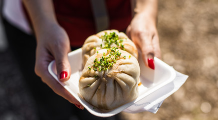 Asian Chinese steamed baozi buns with pork and spring onion at a street food market