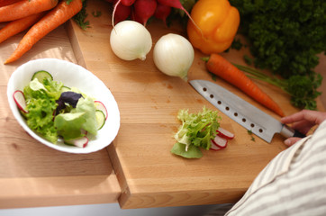 Young woman cutting vegetables in the kitchen