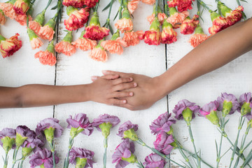 Mothers Day - Mom and Daughter - holding hands and flower background.Love Concept