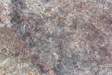 Texture of an uneven surface of a stone, a rock in natural natural conditions, a close-up background