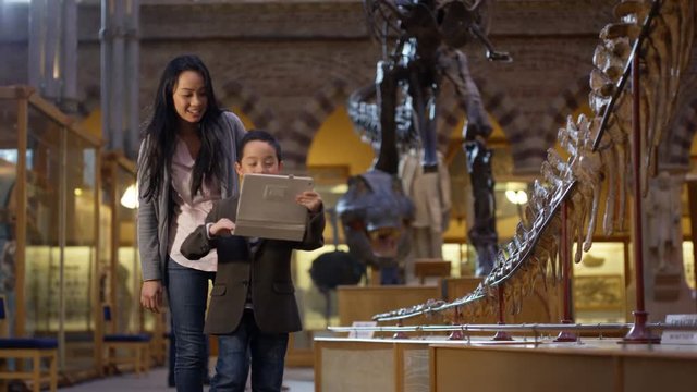  Mother & son in natural history museum pose to take a selfie with tablet