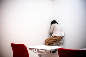 部屋の隅で落ち込む女性