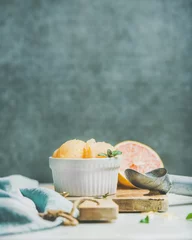  Pink grapefruit homemade sorbet with fresh mint leaves in white bowl on wooden board, grey plywood wall at background, selective focus. copy space. Fresh healthy raw vegan summer dessert concept © sonyakamoz