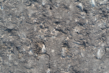 Surface texture of road asphalt with a lot of cracks, cracks, dents and potholes close-up