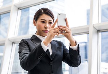 young businesswoman taking a picture with smart phone