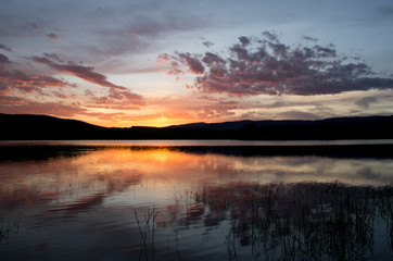 Fototapeta premium Sunset over lake with reflection orange and purple