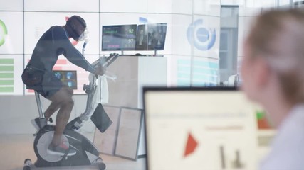  Athlete in science research program being tested by scientists in hi tec lab. 