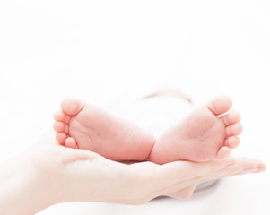 New born babies feet in mothers hands. 