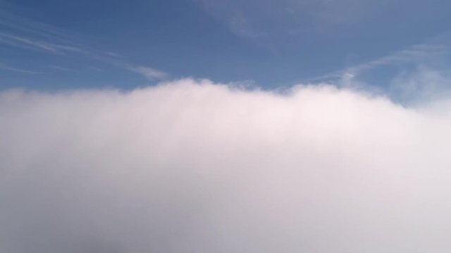 Above the Clouds Rolling by with Blue Sky Background