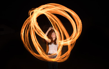 Dancer with flaming fire pois after dark.