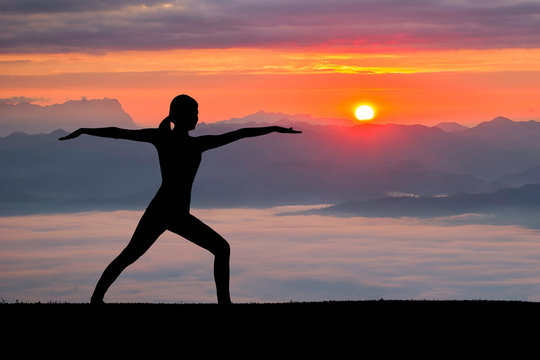Woman practicing warrior yoga pose outdoors at nature background.