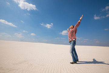 Happy man with open arms stretches towards the sky