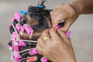 hand of a hairstylist doing a perm rolling hair of senior woman - obrazy, fototapety, plakaty