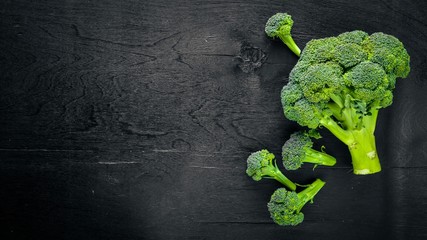 Fresh broccoli on dark wooden table background. top view
