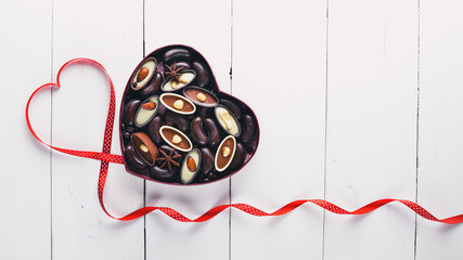 Chocolate box in the form of heart. On a background Wooden. Top view.