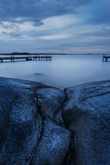 Long exposure of Swedish archipelago coastal landscape with cliffs and jetty 