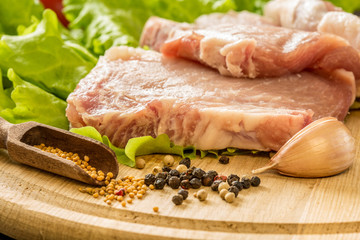 Slices of raw meat. Pork escalope on a wooden board.