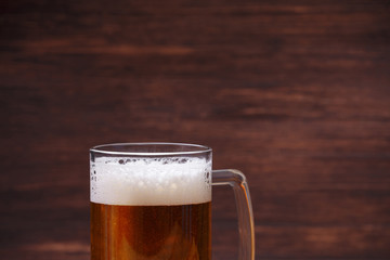 Glass of beer with foam. Mug or pint of ale. Alcohol drink. Pub or bar concept. On rustic wooden background.