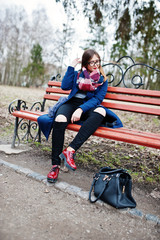 Young girl smoking cigarette outdoors sitting on bench. Concept of nicotine addiction by teenagers.