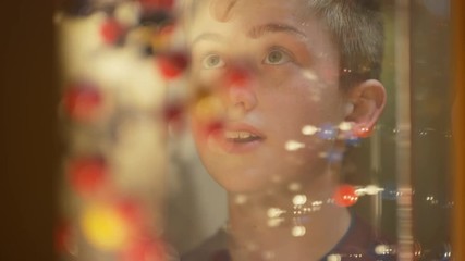  Close up on faces of little boy & mother looking into glass cabinet in museum