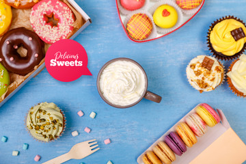 Cupcakes, Macaroons and glazed donuts. Mug with whipped cream. Cakes with buttercream. Almond macaron cookies. Sweet dessert.