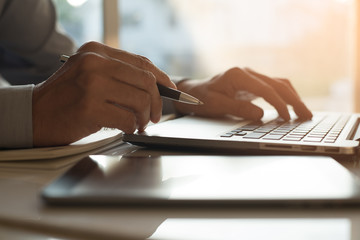 Man working on laptop computer and mobile smartphone