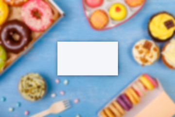 Business card mockup. Cupcakes, Macaroons and glazed donuts. Mug with whipped cream. Cakes with buttercream. Almond macaron cookies.