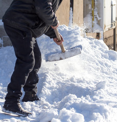 Worker cleans snow shovel