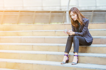 Business women working checking e-mail or relax time playing mobile phone in the outdoor