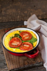 Baked omelet with cheese, spinach and tomatoes