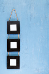 Blank photo frames on blue wood background. Painted scraped wooden board. Grunge plywood texture or pattern.