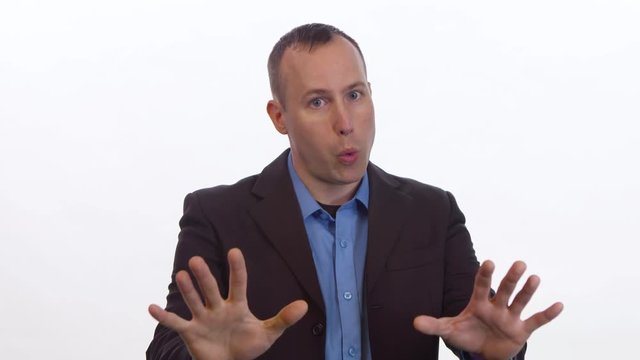 Man gestures disagreement to camera in various gestures on a white background.