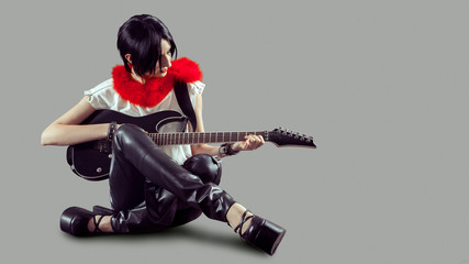 Fototapeta premium Young attractive rock girl playing the electric guitar