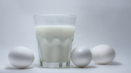 Milk in a glass jar and eggs