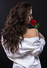 Beautiful brunette with red rose from back