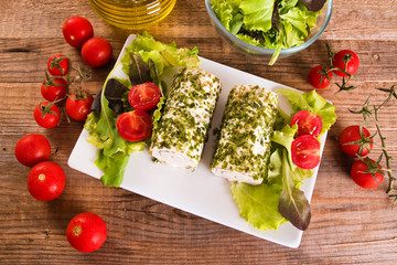 Goat cheese with salad and cherry tomatoes.